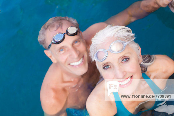 Ältere Paare schwimmen im Pool