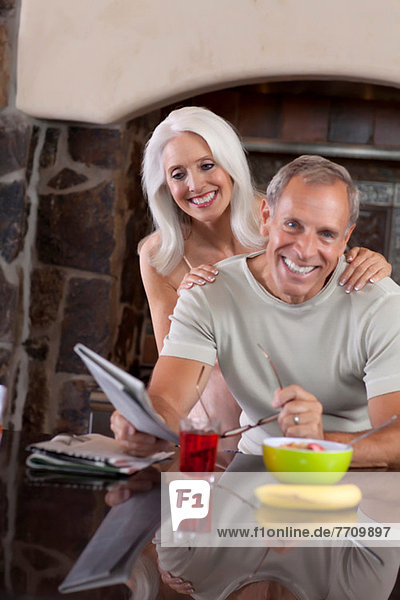 Older couple smiling at breakfast