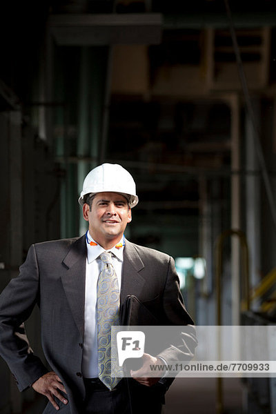 Businessman carrying folder in plant