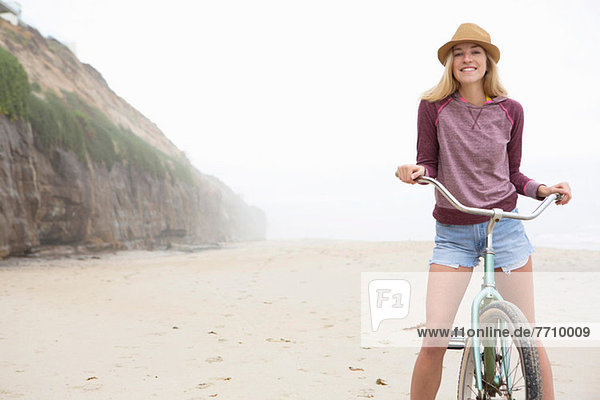 Frau auf dem Fahrrad am Strand