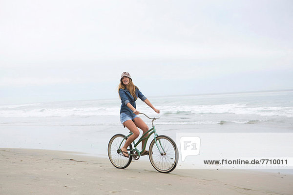 Frau beim Radfahren am Strand