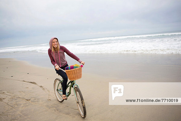 Woman riding bicycle on beach
