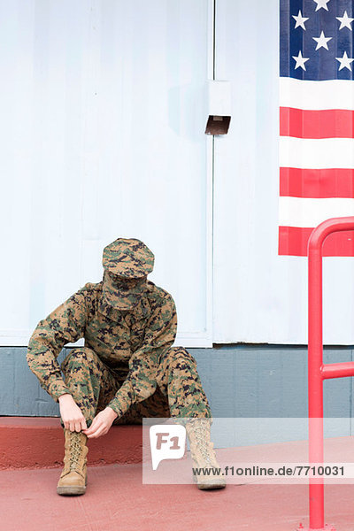 Servicewoman in camouflage by US flag