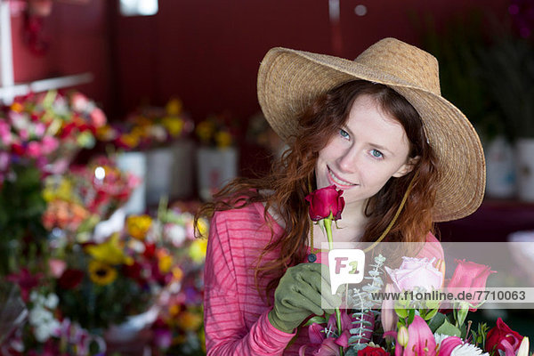 Florist smelling flowers in shop