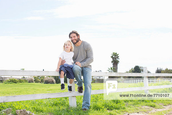 Father with son on wooden fence