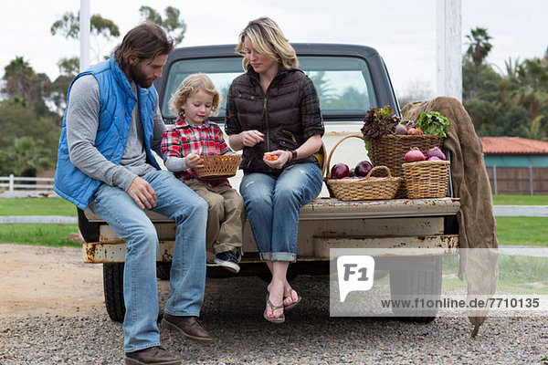 Family with produce in truck bed