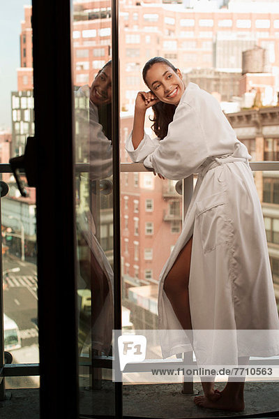 Woman wearing bathrobe on balcony