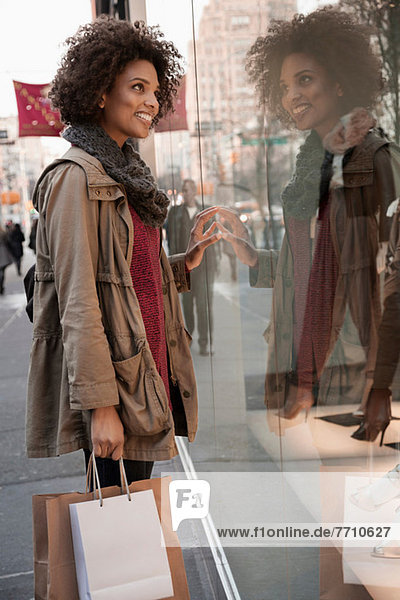 Woman window shopping on city street