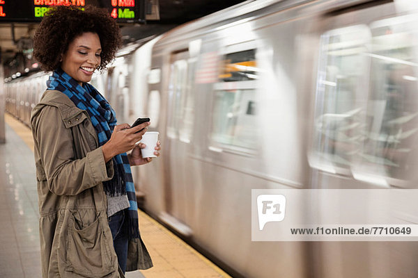 Woman using cell phone at subway station