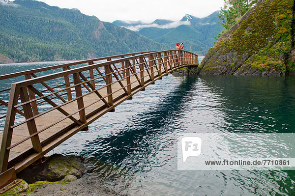 Woman taking picture on wooden bridge