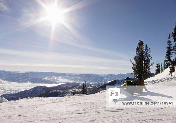 Snowboarders sitting on slope