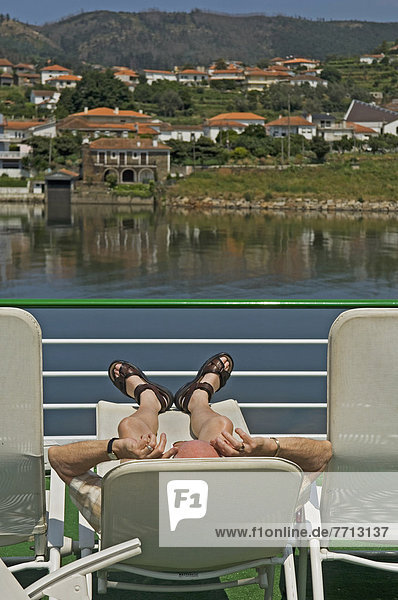A Man Relaxing On Deck Aboard A Douro Valley River Cruise