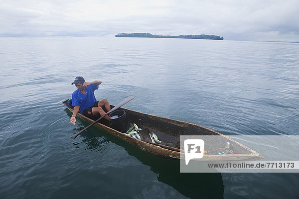 Man fishing in canoe type dugout boat  panama