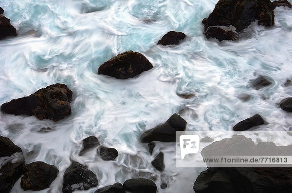 Black Volcanic Rocks In Sea