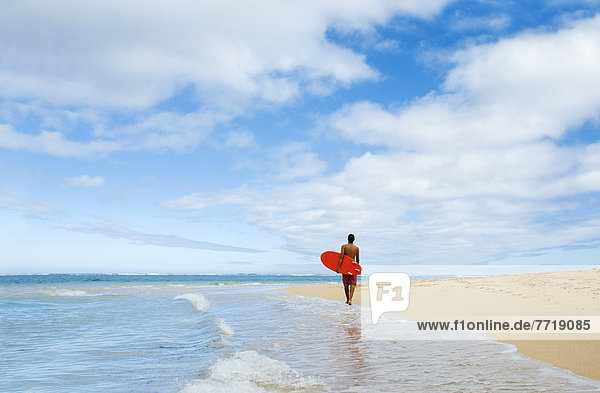 Hawaii  Kauai  Man Walking Along Beach With Surfboard  View From Behind.