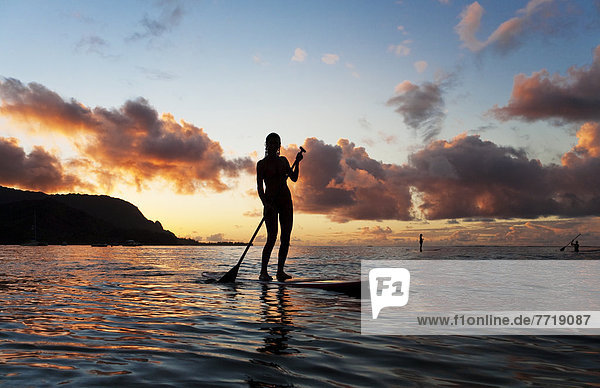 Hawaii  Kauai  Woman Stand Up Paddling In Ocean  Beautiful Sunset.