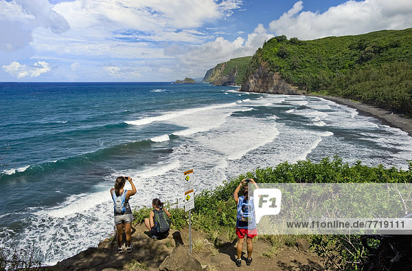 Hawaii  Big Island  North Kohala  Pololu Valley Trail  Women Hikers Overlooking Ocean. For Editorial Use Only.