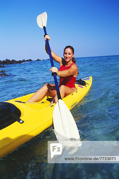Woman In Red Bathing Suit Paddling Kayaking In The Ocean.