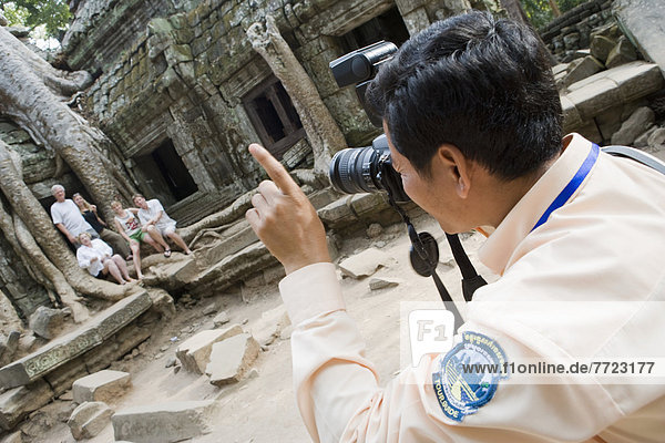 Man Taking Photo Group Of People At Temple Of Ta Prohm  Siem Reap  Cambodia