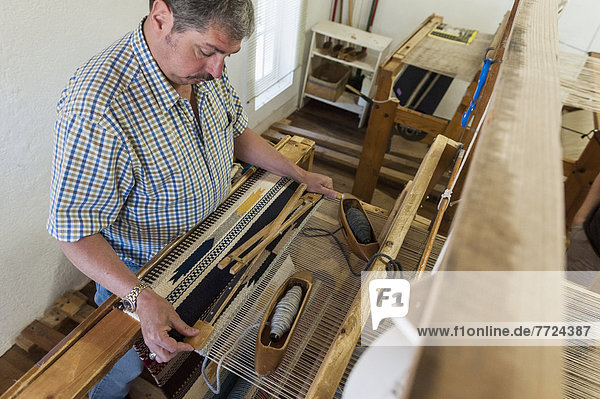 High Angle View Of A Man Working On Loom Demonstration At Ortega's Weaving Shop  New Mexico  Usa