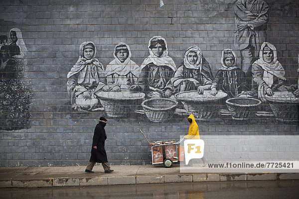 Street Cleaner In Front Of Mural Of Famous Kurdish People  Sulaymaniyah  Iraqi Kurdistan  Iraq