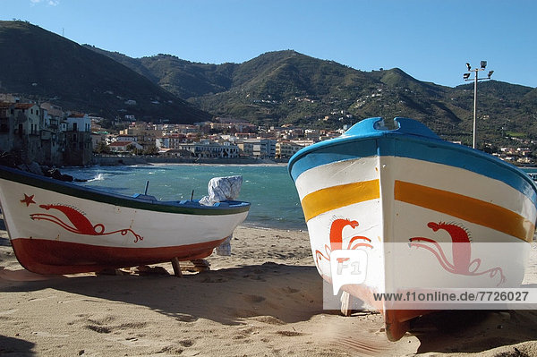 Sicily  Italy: boats decorated with traditional sea-horse motifs on the small beach in the harbour in the old town of Cefalu. Copyright . © Anna Watson / Axiom
