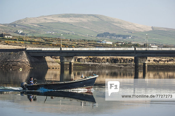 UK  Ireland  County Kerry  Iveragh Peninsula  Fisherman in motorboat trawling on tranquil water  Portmagee