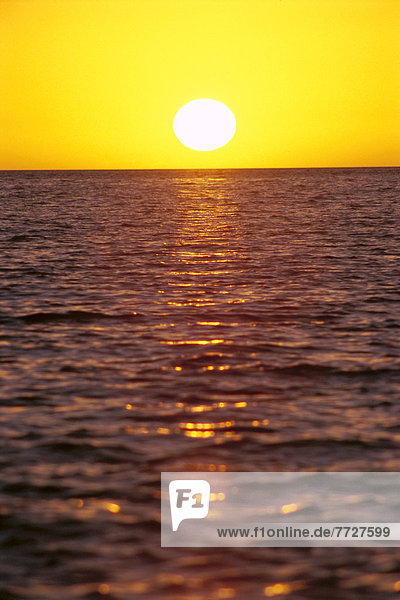 Tropical Sunset With Yellow Sky  Sun Ball Over Ocean  Shimmering Reflections