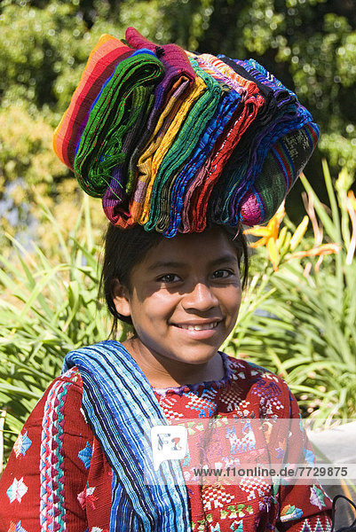 Guatemala  Lake Atitlan  Indigenous Girl Carrying Textiles For Sale On Her Head
