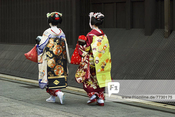 Two Maikos (Apprentice Geishas) Walking Away In A Street  Kyoto  Japan