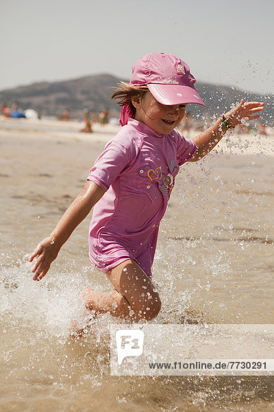 Young Girl Splashing Through The Water At The Beach  Tarifa  Cadiz  Andalusia  Spain
