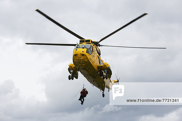 Rescue Workers Hang From A Helicopter In Mid-Air  Northumberland England