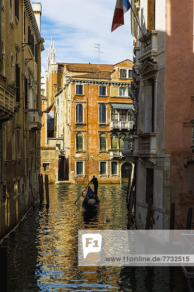 Rowing gondola through canal  Venice  Italy