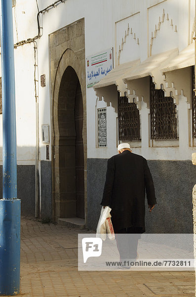 Senior man walking with shopping bag  Old Medina  Casablanca  Morocco