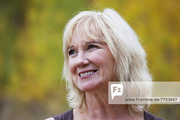 Portrait Of A Mature Woman Smiling In A Park With Autumn Colours  Edmonton  Alberta  Canada
