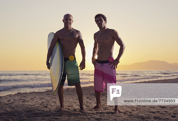 Two Young Men Standing On The Beach With A Surfboard  Tarifa  Cadiz  Andalusia  Spain