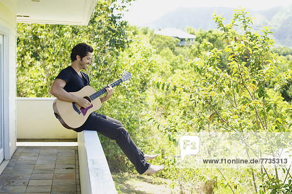 sitzend  Mann  Amerika  Spiel  Balkon  Gitarre  barfüßig  Fenstersims  Verbindung  Hawaii  Kauai