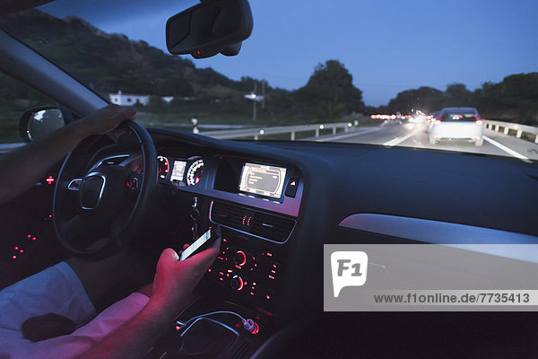 A Driver Uses A Cell Phone While Driving At Dusk  Tarifa Cadiz Andalusia Spain