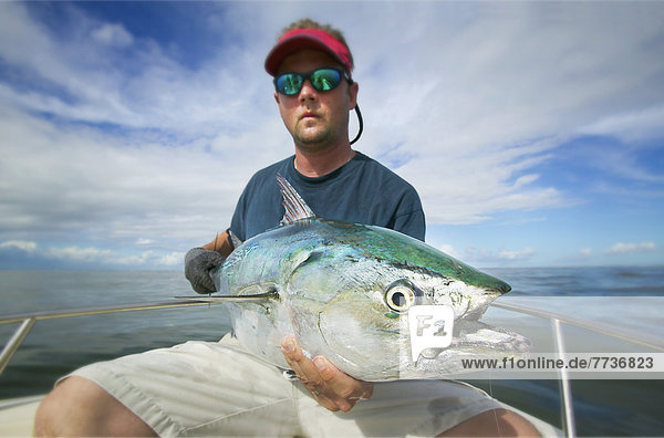 Man holding a false albacore tuna off the coast of north carolina  north carolina united states of america