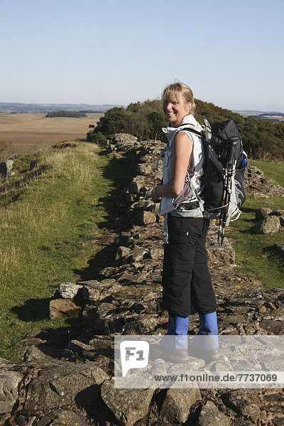 A woman hikes along hadrian's wall Northumberland england