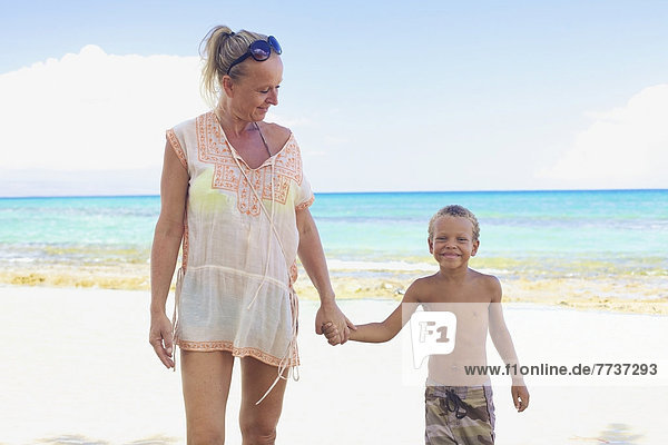 A mother and son holding hands on the beach Hawaii united states of america