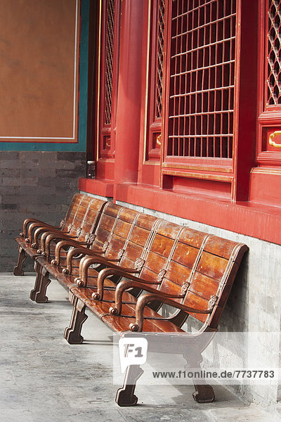 Wooden seating against a concrete and red wall Forbidden city beijing china
