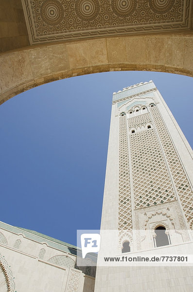 A tall white tower against a blue sky Casablanca morocco