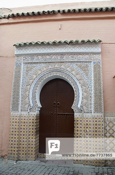 A horseshoe shaped door with ornate facade on the arched entrance Marrakech morocco