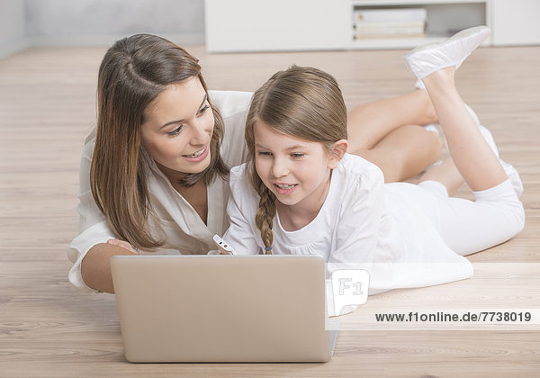 Mutter und Tochter schauen in Laptop