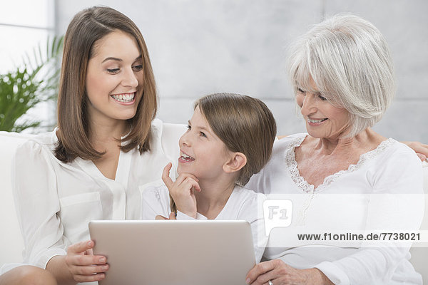 Großmutter  Tochter und Enkelin schauen in Laptop