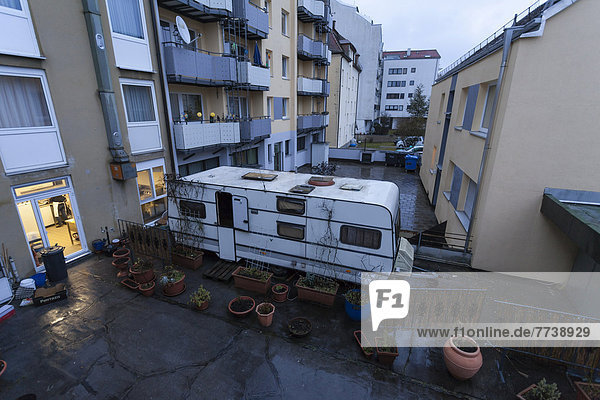 Depressing rear courtyard with caravans and flower pots