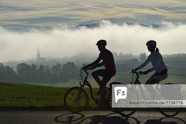 Cyclists riding electric bicycles  Matzing  Lake Waller  Neumarkt  Salzburg Lake District  Salzburg  Austria  Europe