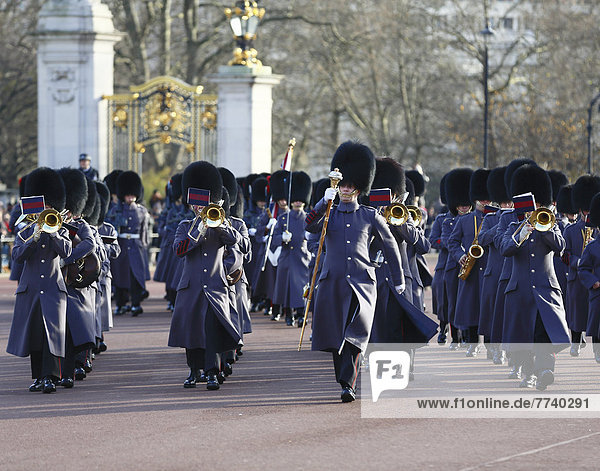 Changing of the Guard at Buckingham Palace  soldiers wearing a gray uniform  military band