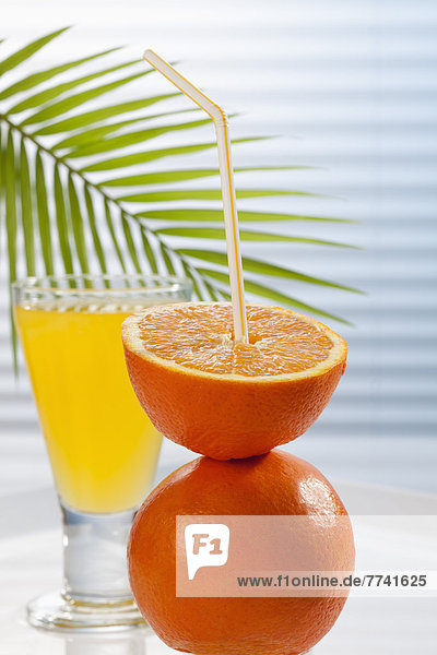 Glas Orangenlimonade neben Orangen auf dem Tisch  Nahaufnahme